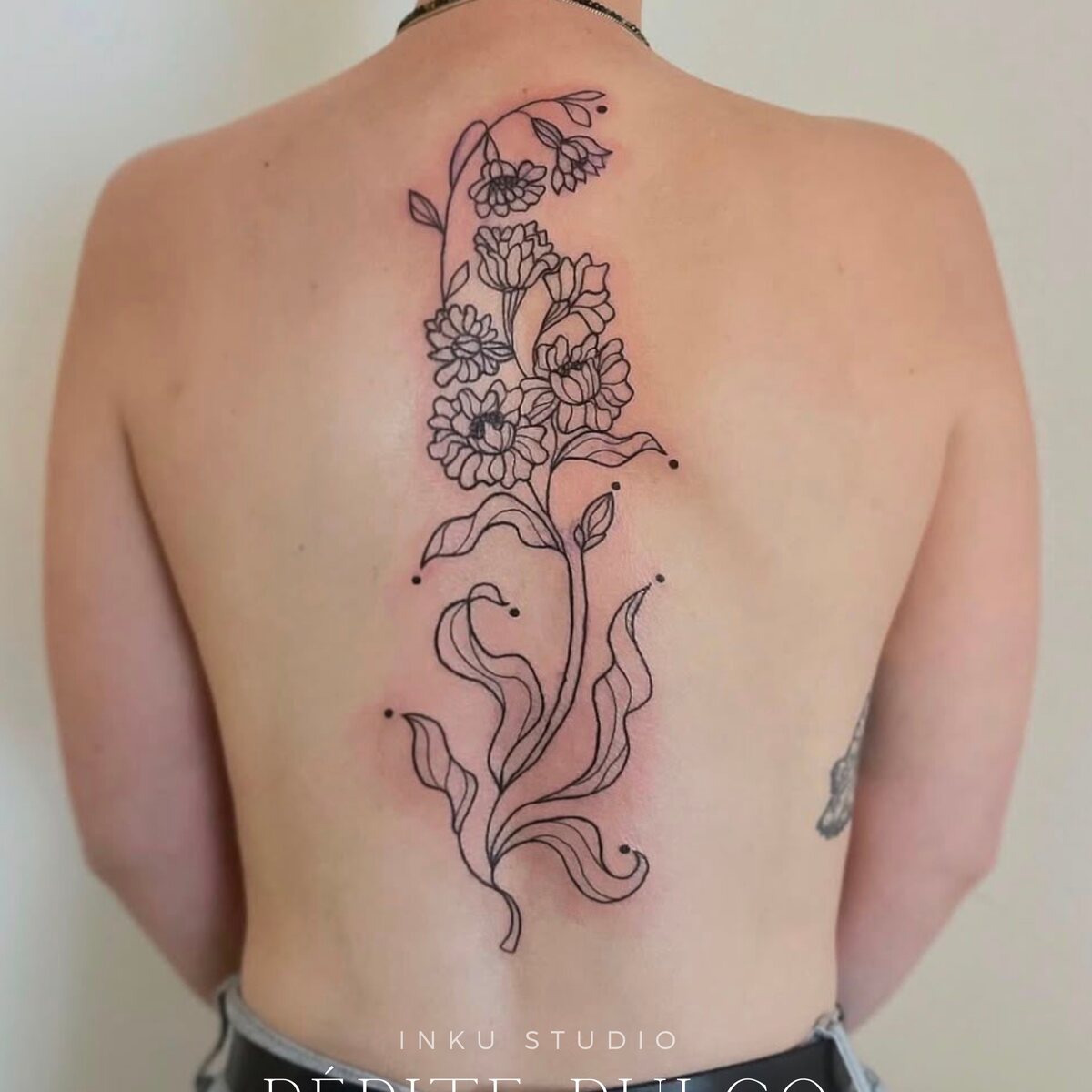 Grande composition florale en fine line dans le dos